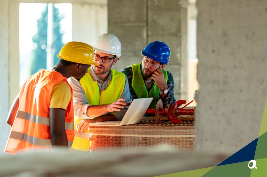 Construction workers looking at a laptop with a construction accounting software on-site