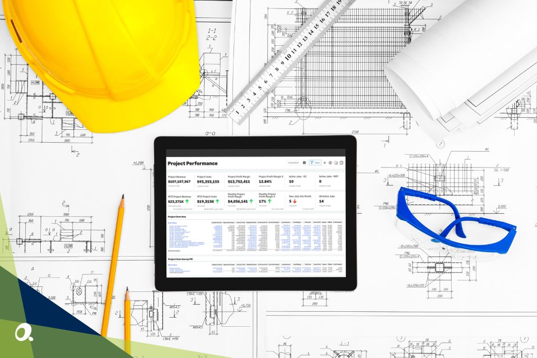 Construction-related items on a desk surrounding a tablet featuring Sage Intacct Construction