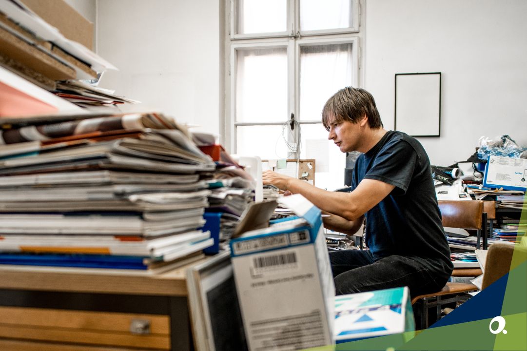 A finance manager surrounded by stacks of paperwork