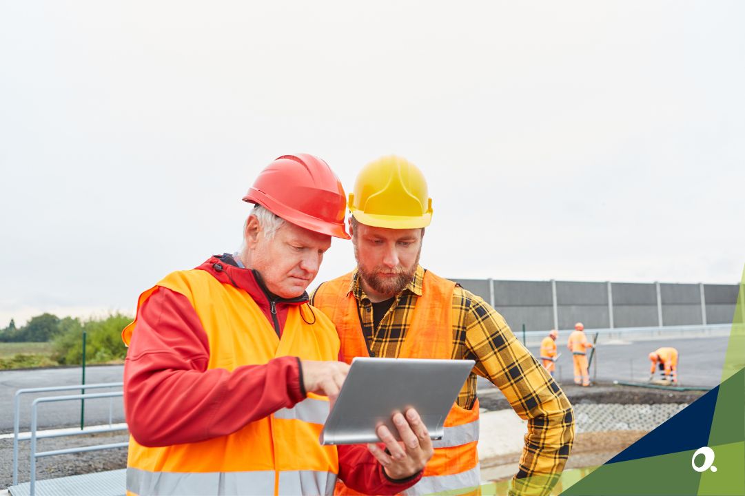 Two construction workers reviewing construction accounting software on a tablet