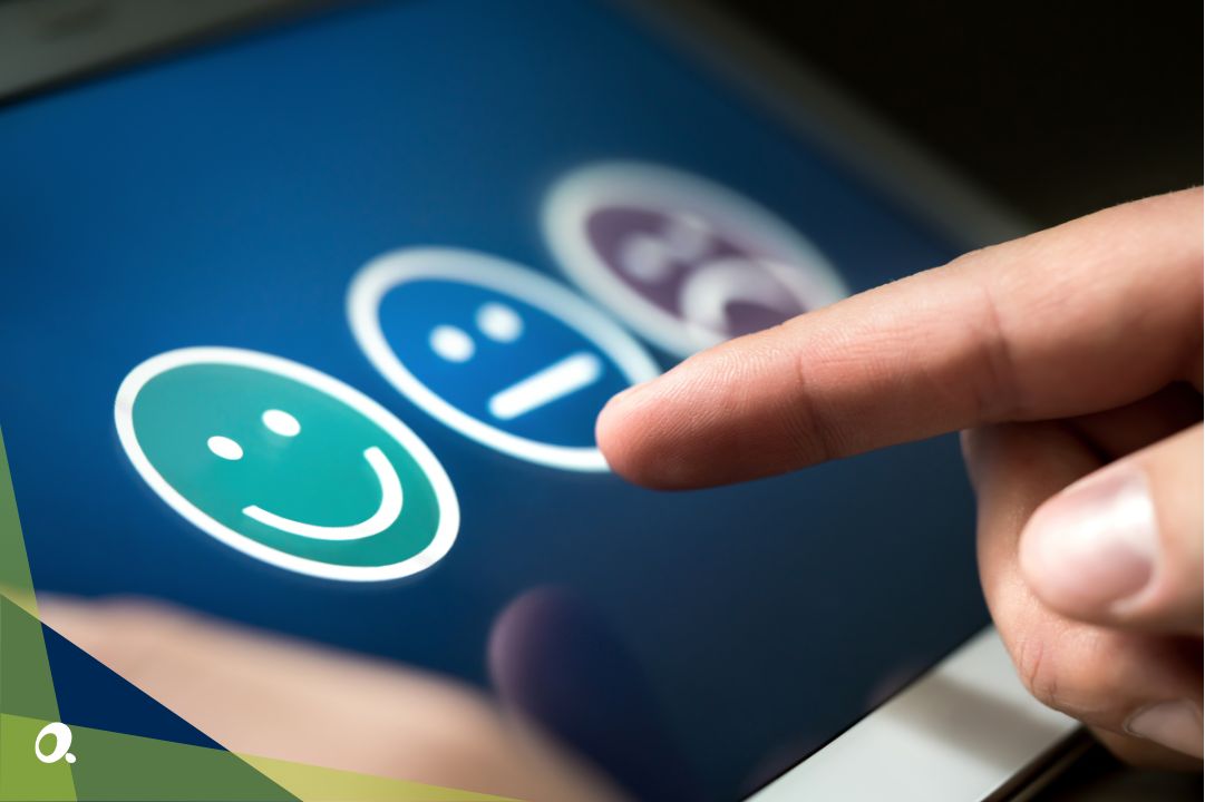 A close up of a tablet with three smiley faces showing customer satisfaction