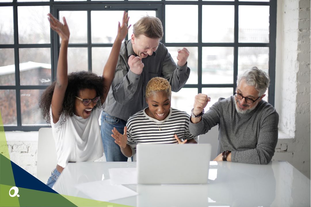 A team gathered around a laptop, smiling as they review a modern financial management solution on the screen.