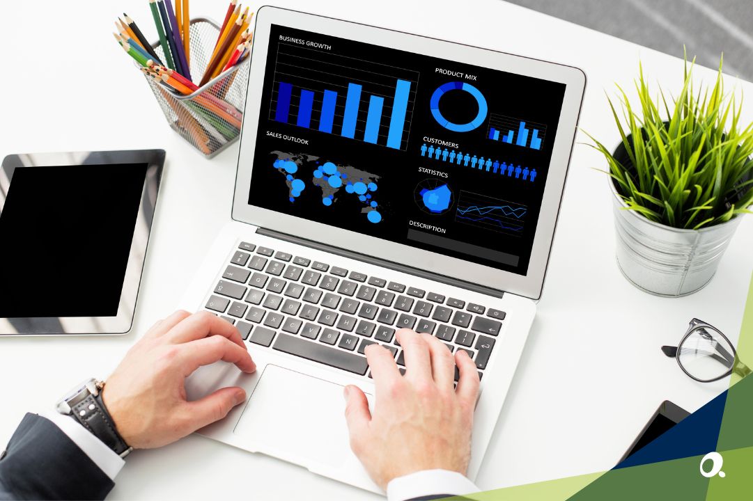 Person working on a laptop displaying business analytics dashboards, with charts for growth, sales outlook, product mix and global metrics