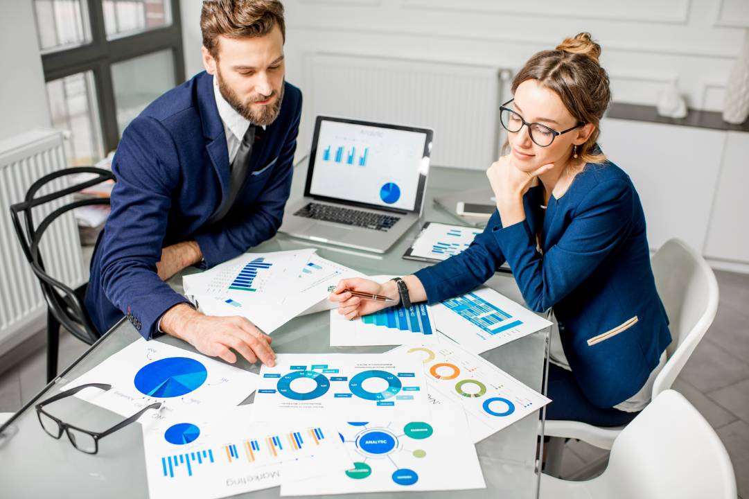 A man and a woman working together amongst financial paperwork